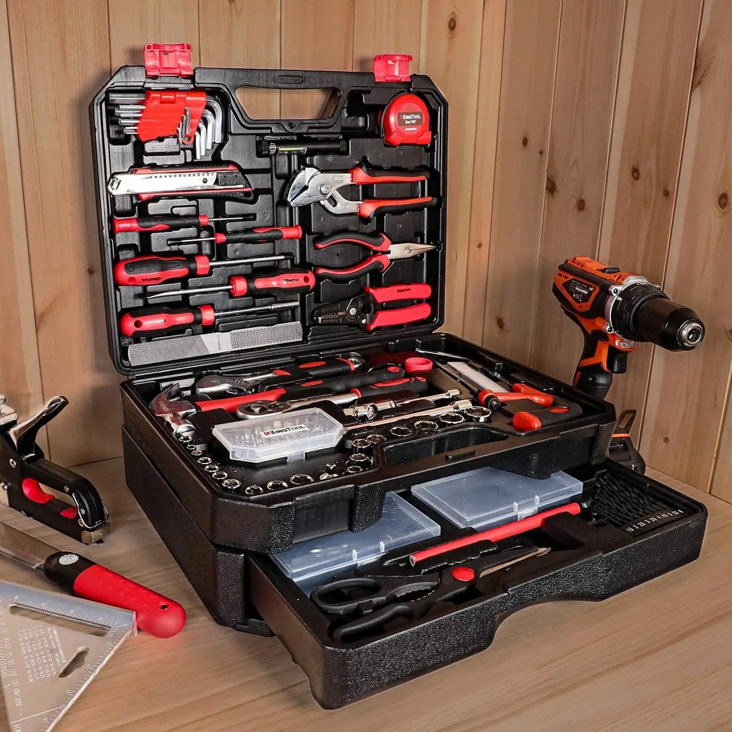 Tool kit on a wooden workbench with tool case flipped open displaying tools and a drawer slightly open showing more tools
